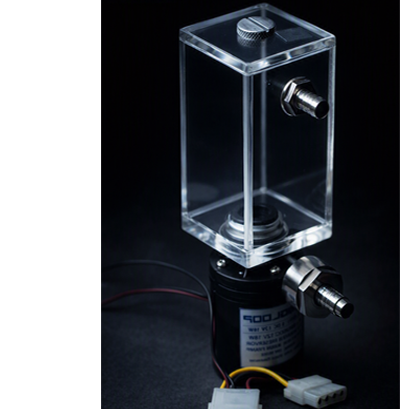 A computer liquid cooling pump and reservoir assembly illuminated by cool bluish‑white light against a dark background. The transparent acrylic reservoir with metal fittings sits atop a black cylindrical pump labeled “RIGLOOP DC 12V 18W.” Power cables and connectors extend from the pump, resting on a dark surface